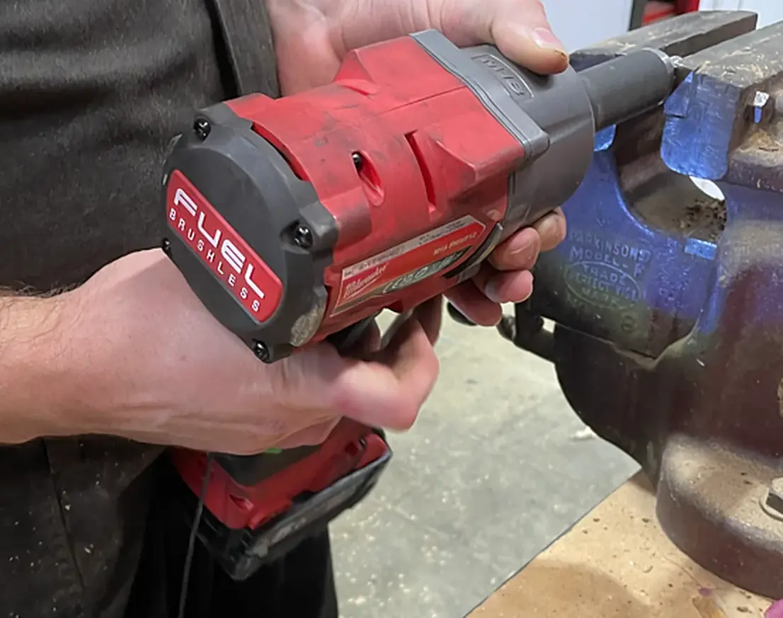 Cordless impact wrench measured in use at the bench vice in the boat workshop