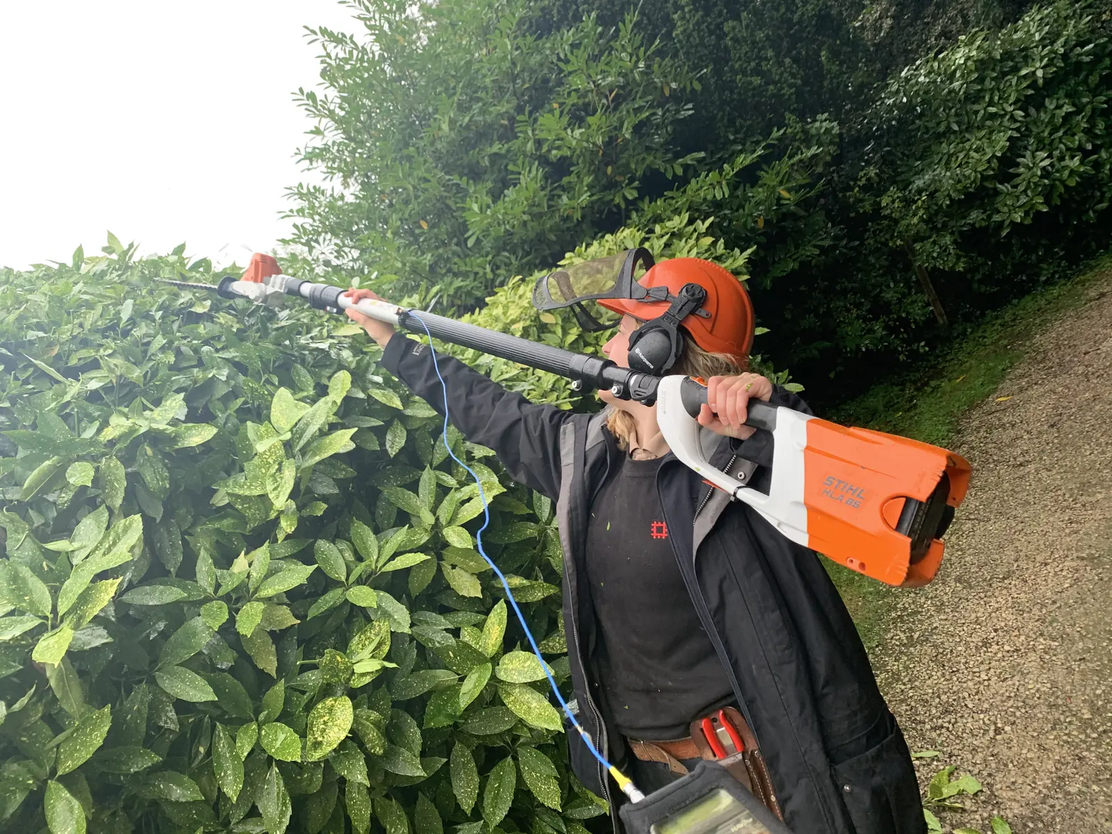 Wired triaxial vibration sensor and belt-worn data logger measuring a battery long-reach hedge trimmer in use