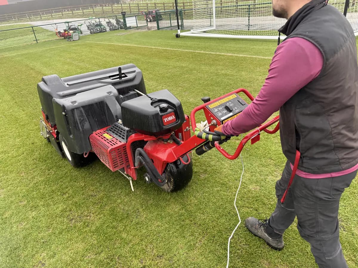 Wired vibration sensor cabled to a pedestrian aerator on a training-ground pitch