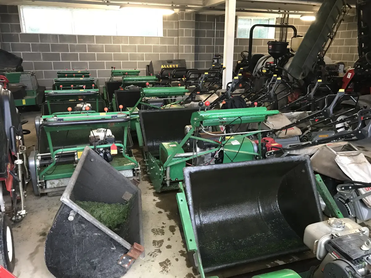 Machine shed full of cylinder mowers and grass boxes between shifts