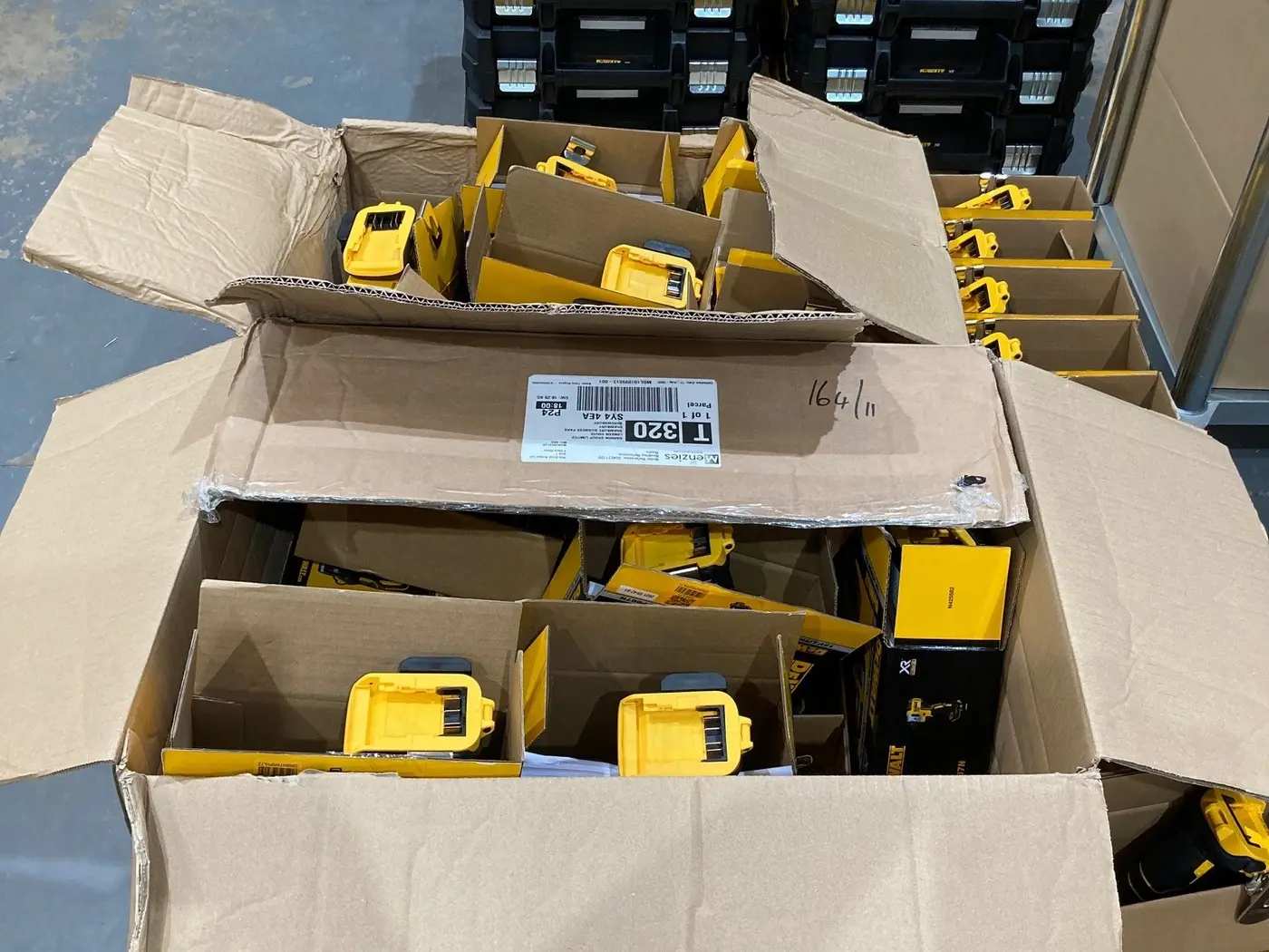 Open boxes of drill batteries part-way through batch marking